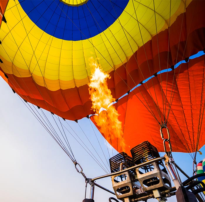 Nahaufnahme der Flamme eines bunten Heißluftballons, der vom Airport aufsteigen will.