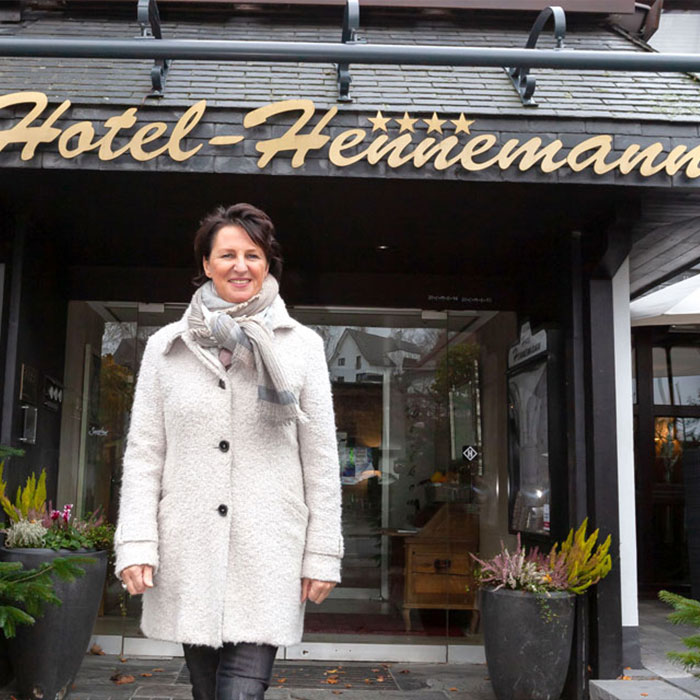 Man sieht Hotel-Chefin Renate Bangemann vor ihrem Hotelgebäude.